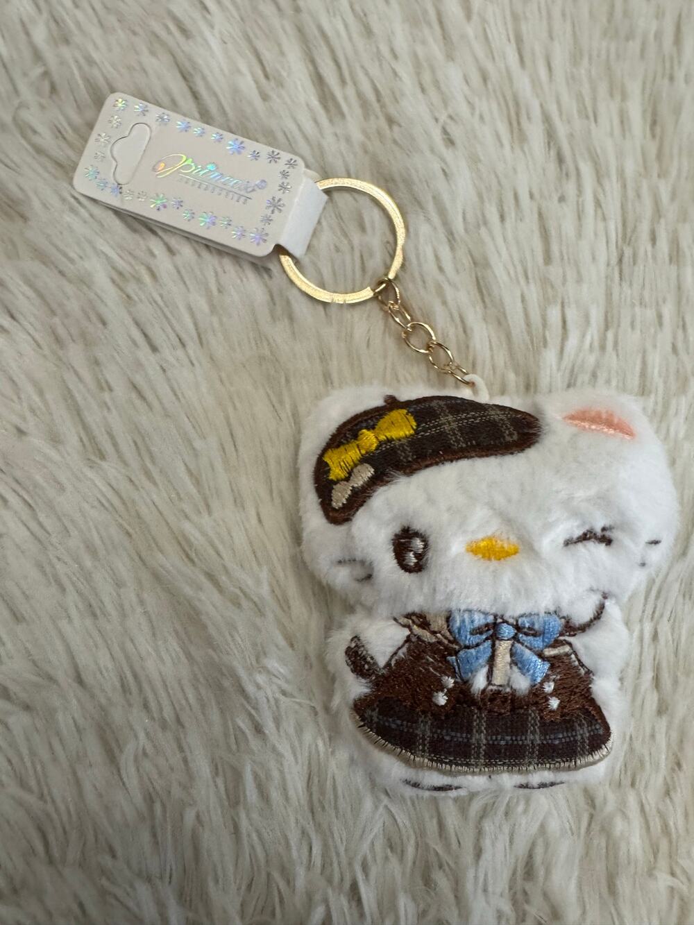 Hello Kitty plush keychain embroidered with brown plaid outfit and blue bow